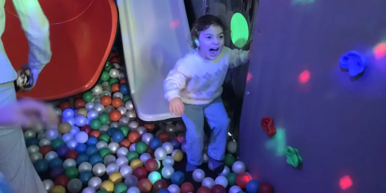 Child playing in the ball pit inside the Essex Soft Play Bus with colourful slide and soft play climbing wall.