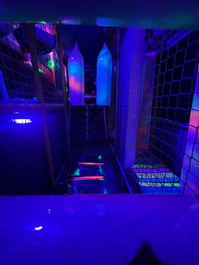 Children’s soft play climbing tunnel and walkway inside the Essex Soft Play Bus with colourful LED lighting and indoor play equipment.