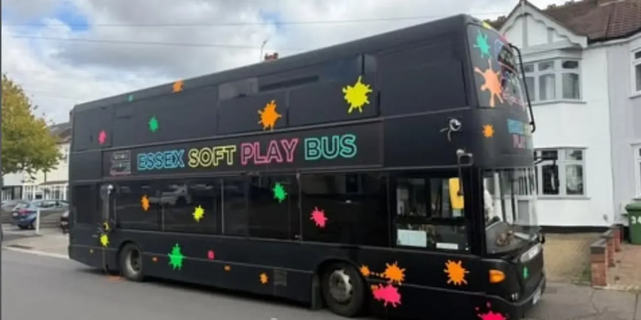 The Essex Soft Play Bus double decker children's soft play party bus lit up at night outside a birthday party in Essex