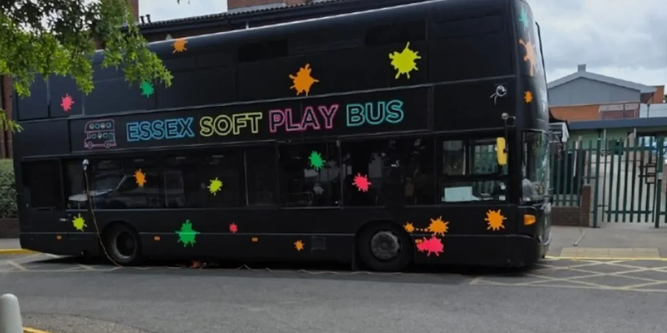 The Essex Soft Play Bus double decker children's soft play party bus parked outside a school in Essex