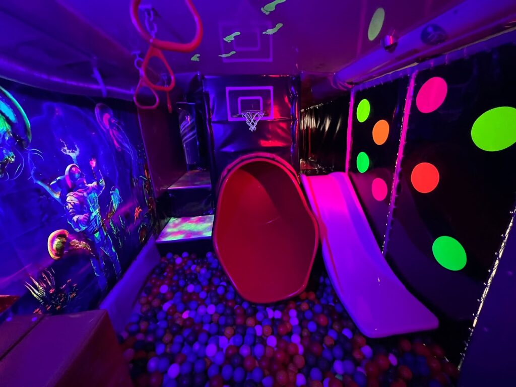 Neon slide and ball pit inside Essex Soft Play Bus