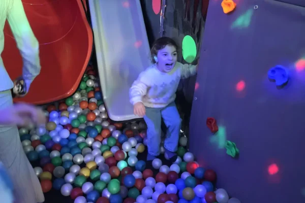Children Playing in the Ball Pit Inside the Essex Soft Play Bus Child playing in the ball pit inside the Essex Soft Play Bus with colourful slide and soft play climbing wall.