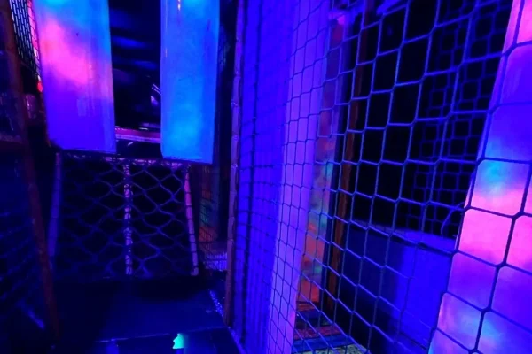 Neon Soft Play Climbing Frame Inside the Essex Soft Play Bus Neon soft play climbing frame and tunnel area inside the Essex Soft Play Bus with colourful UV lighting and indoor play equipment.